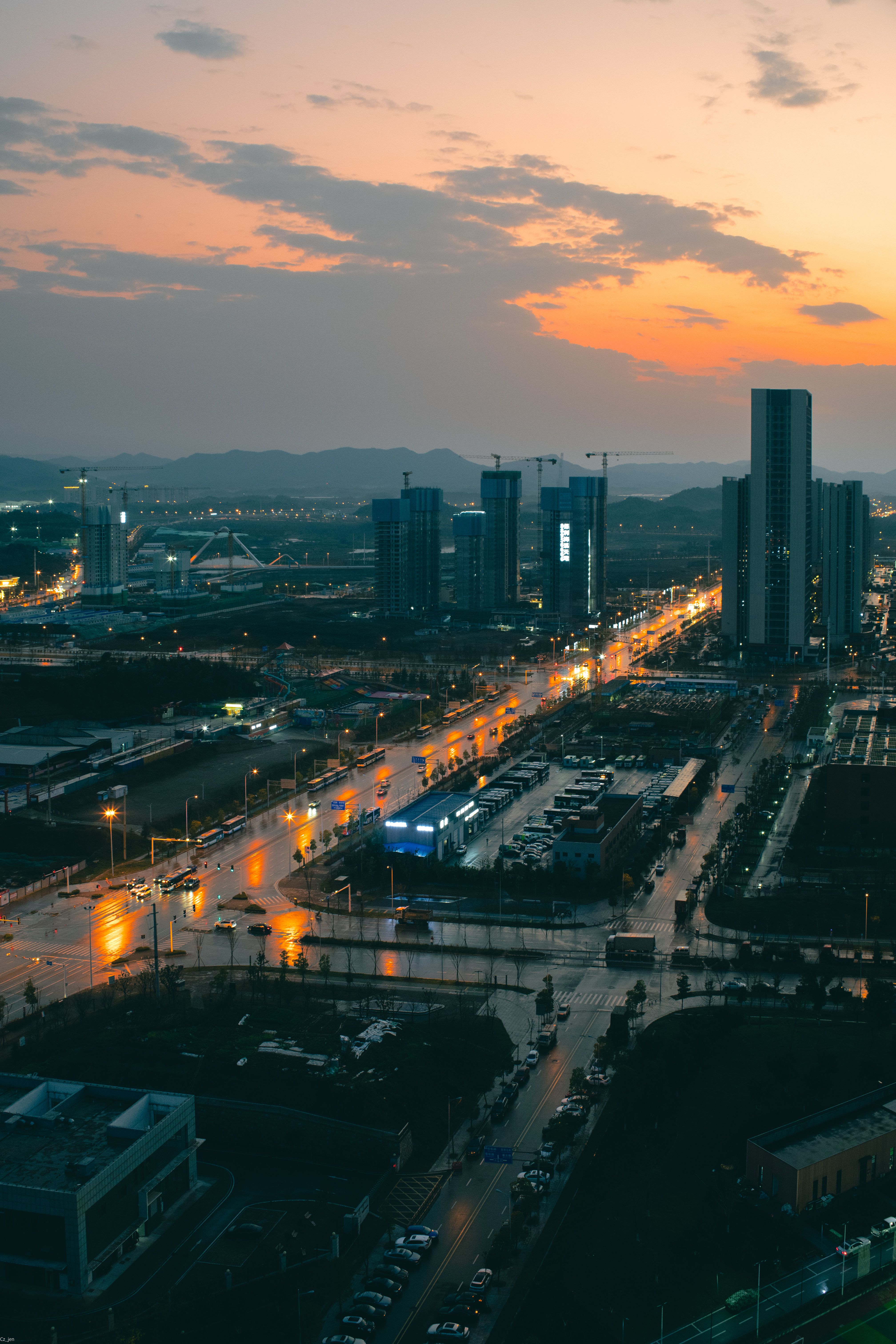 Stunning aerial view of an urban cityscape at dusk, showcasing a vibrant skyline and illuminated streets.