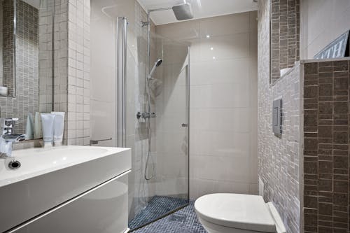 A bathroom with a shower, sink and toilet