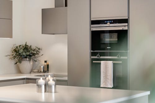 A modern kitchen with a stainless steel oven and a microwave