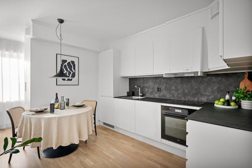 A black and white kitchen with a table and chairs