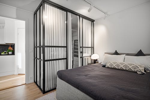 A bedroom with a bed, a closet and a window