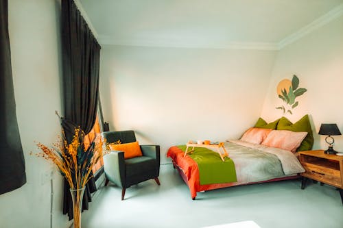 A bedroom with a green and orange bedspread