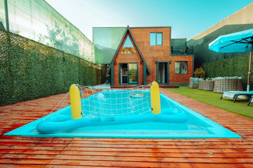 A pool with a blue inflatable raft and a wooden deck