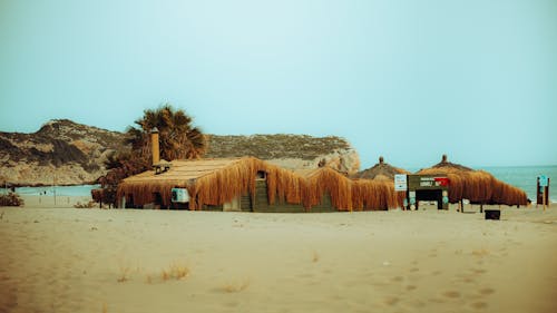 A hut on the beach with a straw roof