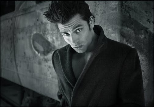 Stylish black and white portrait of a man with striking hairstyle in a coat.