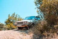 一辆经典汽车停在郁郁葱葱的厄兹代雷景观中，捕捉着怀旧与永恒之美