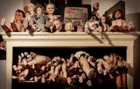 架子上摆放着各种怪异的复古娃娃，营造出一种怪异的氛围