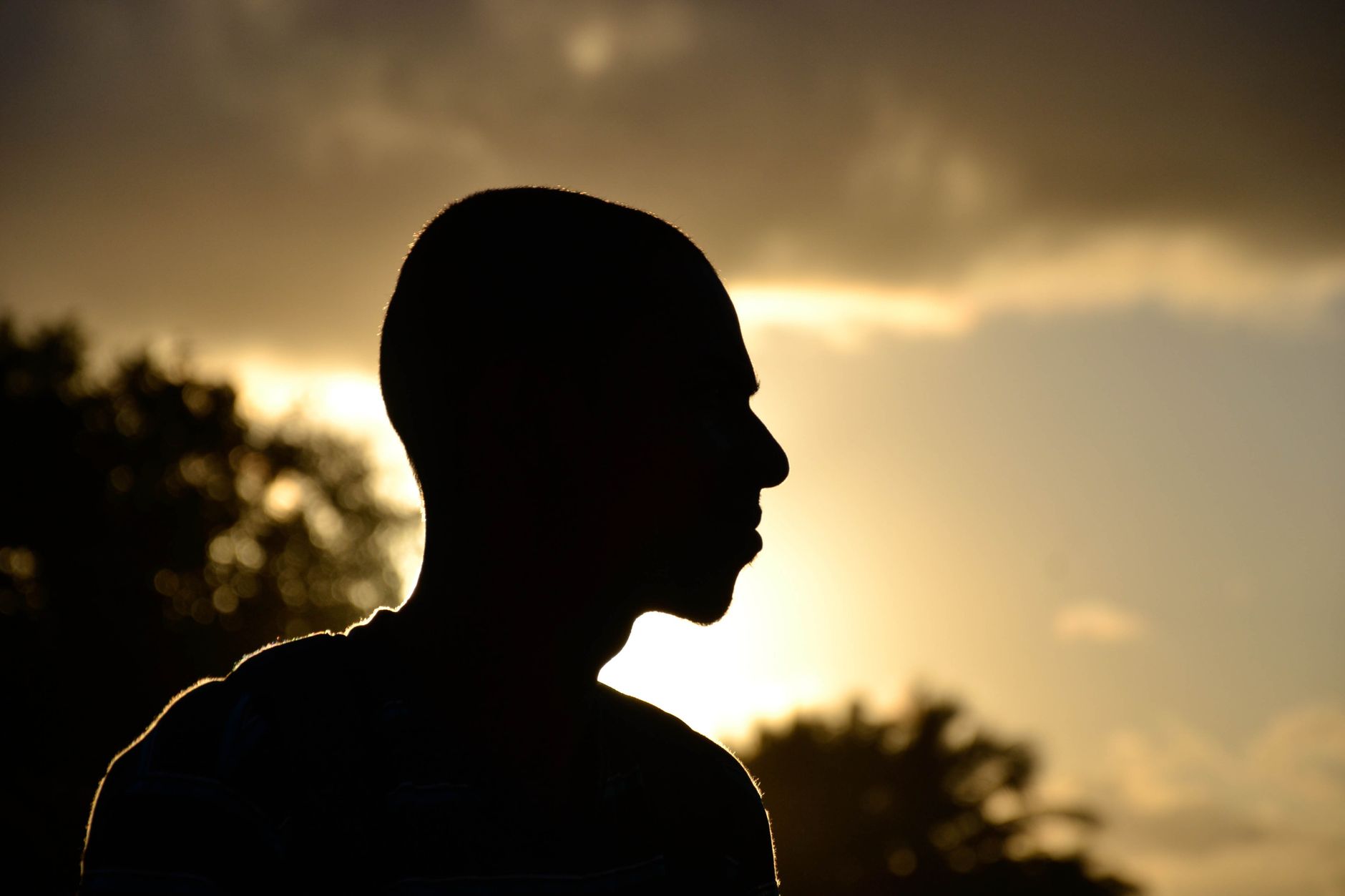 A dramatic silhouette of a person against the evening sky with sunset glow.. dramatic, silhouette, person