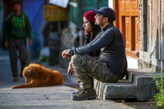 一对夫妇坐在街边的台阶上，旁边有只狗，正观察着周围的环境