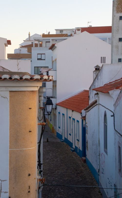 Free Explore the narrow cobblestone alleyways of Sines, Portugal, featuring traditional whitewashed homes. Stock Photo