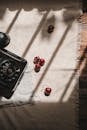 A black telephone on a table with cherries