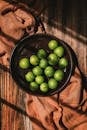 Green apples in a bowl on a wooden table