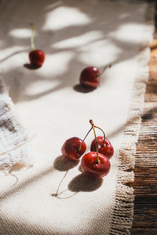 Cherries on a table with a cloth on top