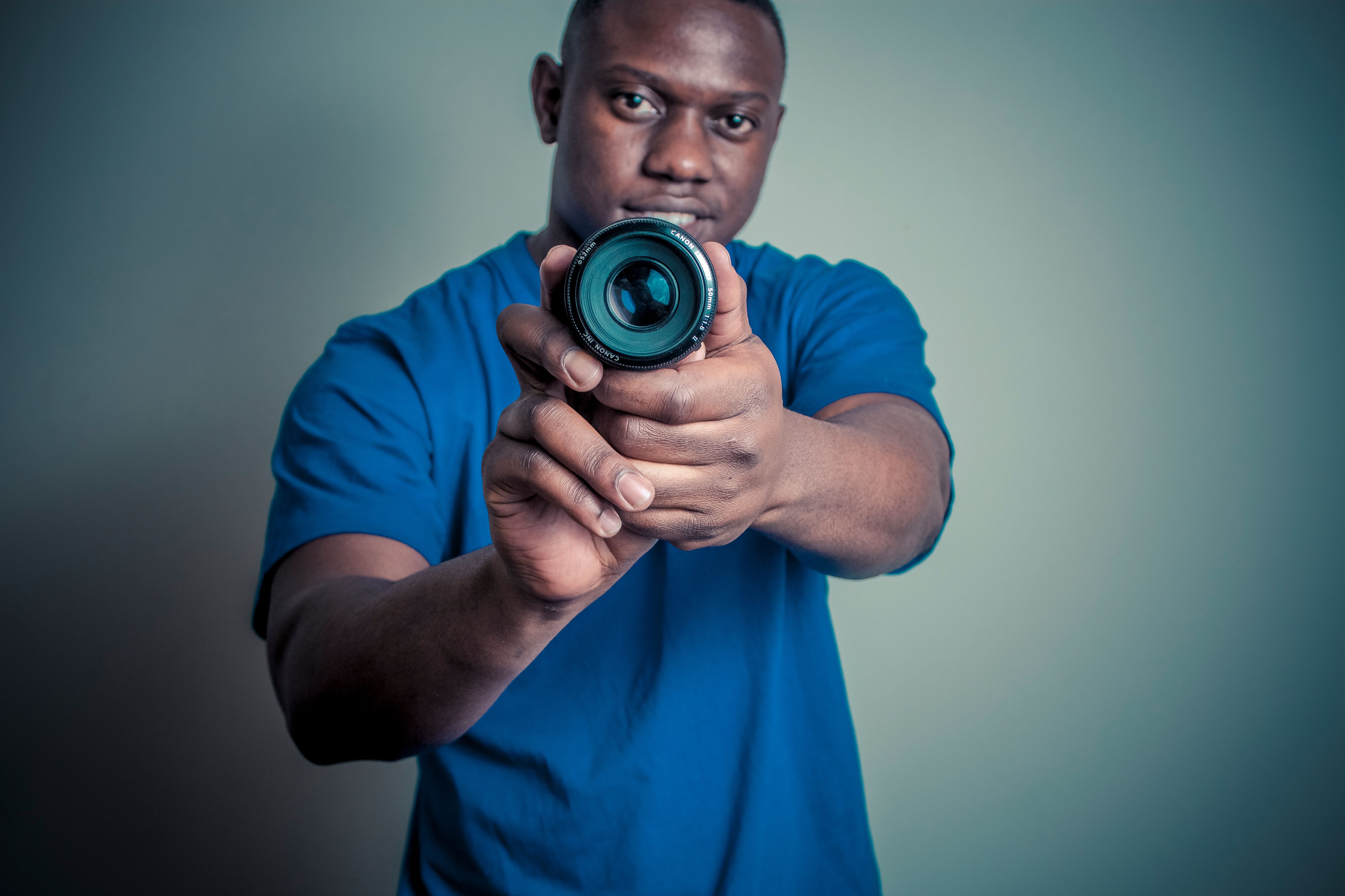 a person placing a piece of tape over a smart home camera lens with a determined expression