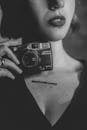 Woman Holding a Retro Camera in Black and White 