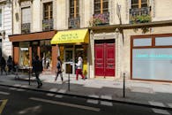 阳光明媚的日子里，迷人的巴黎精品店旁，人们走过，复古建筑与热闹的街头生活尽展眼前