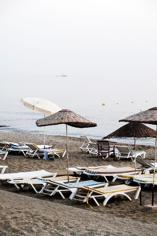 Free Serene beach scene in Alanya, Turkey with sun loungers and umbrellas by the calm sea. Stock Photo