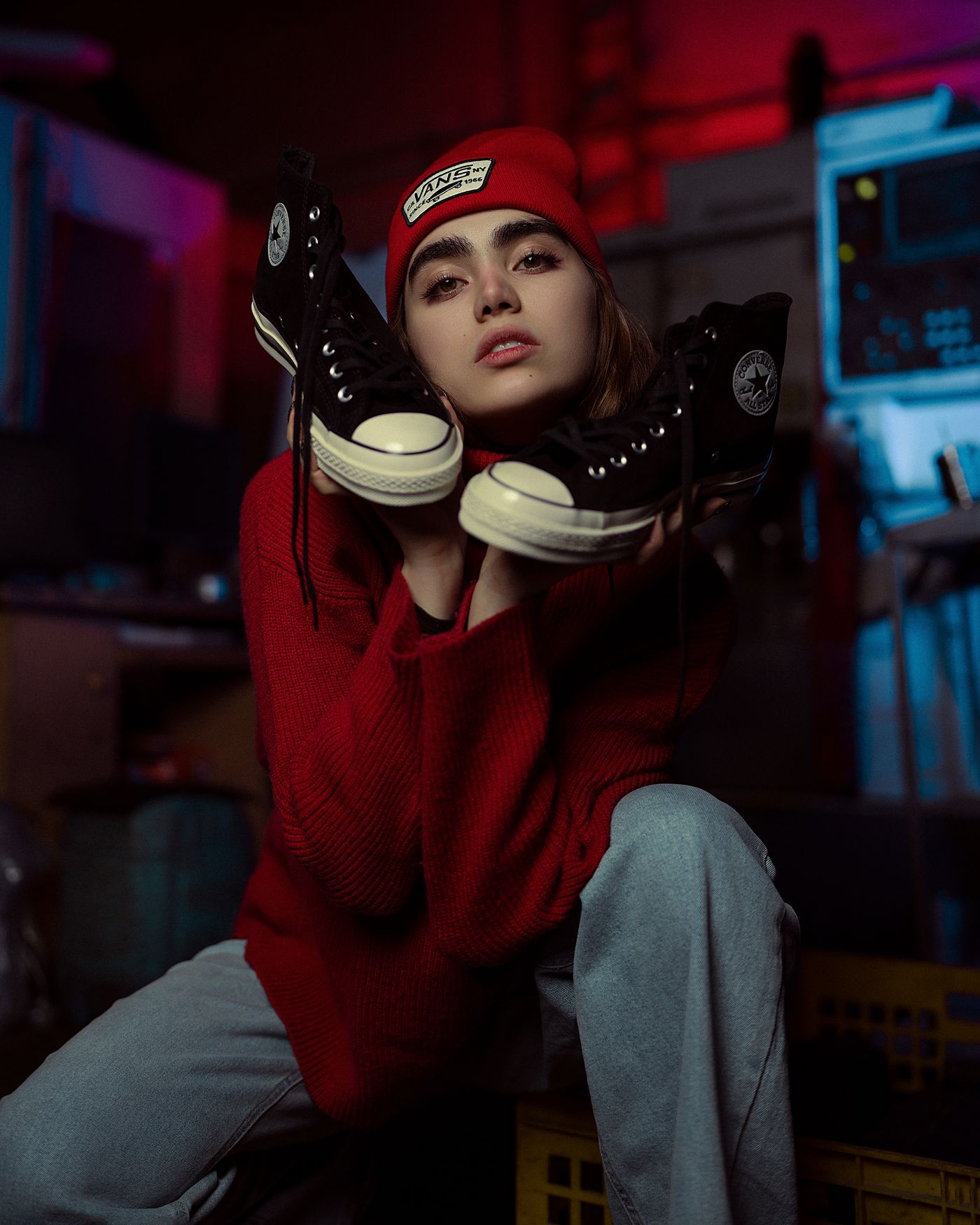 Clienta con gorro rojo sostiene un par de zapatillas negras en el taller de la tienda