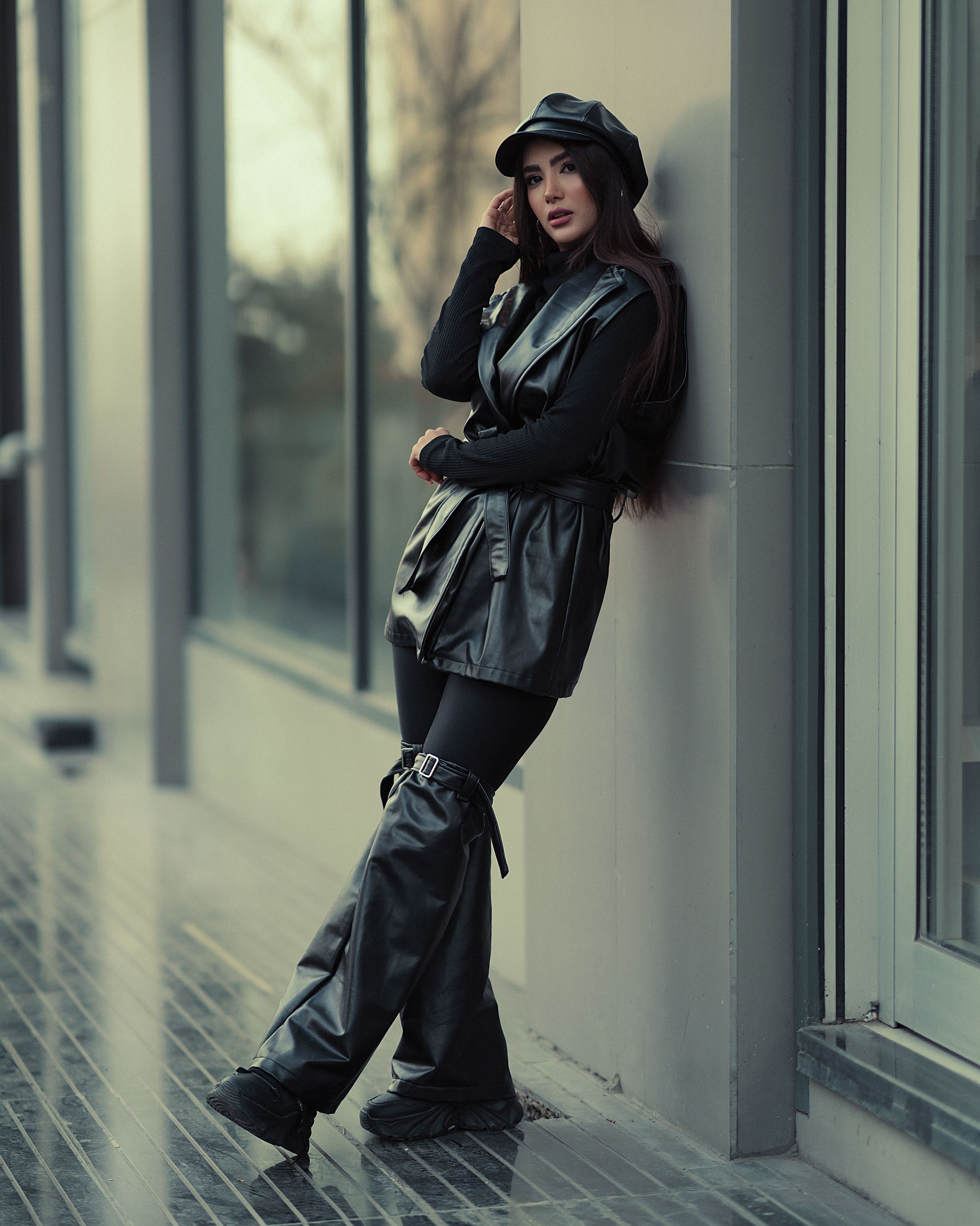 A woman in black leather pants and boots leaning against a wall · Free ...