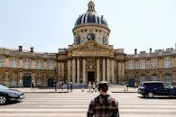 在历史悠久的巴黎法兰西学院前，人们正过马路