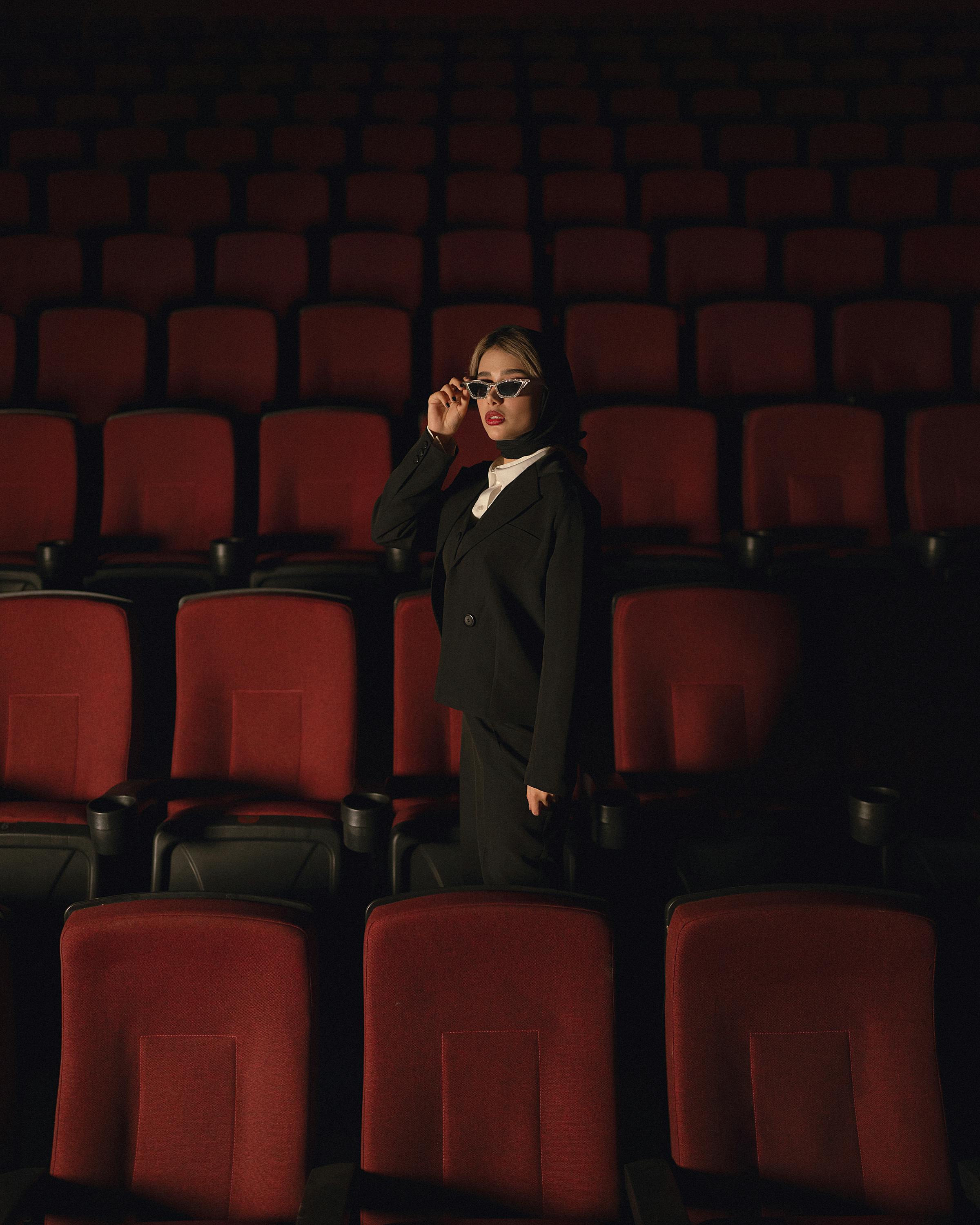 elegant woman standing alone in a movie theater