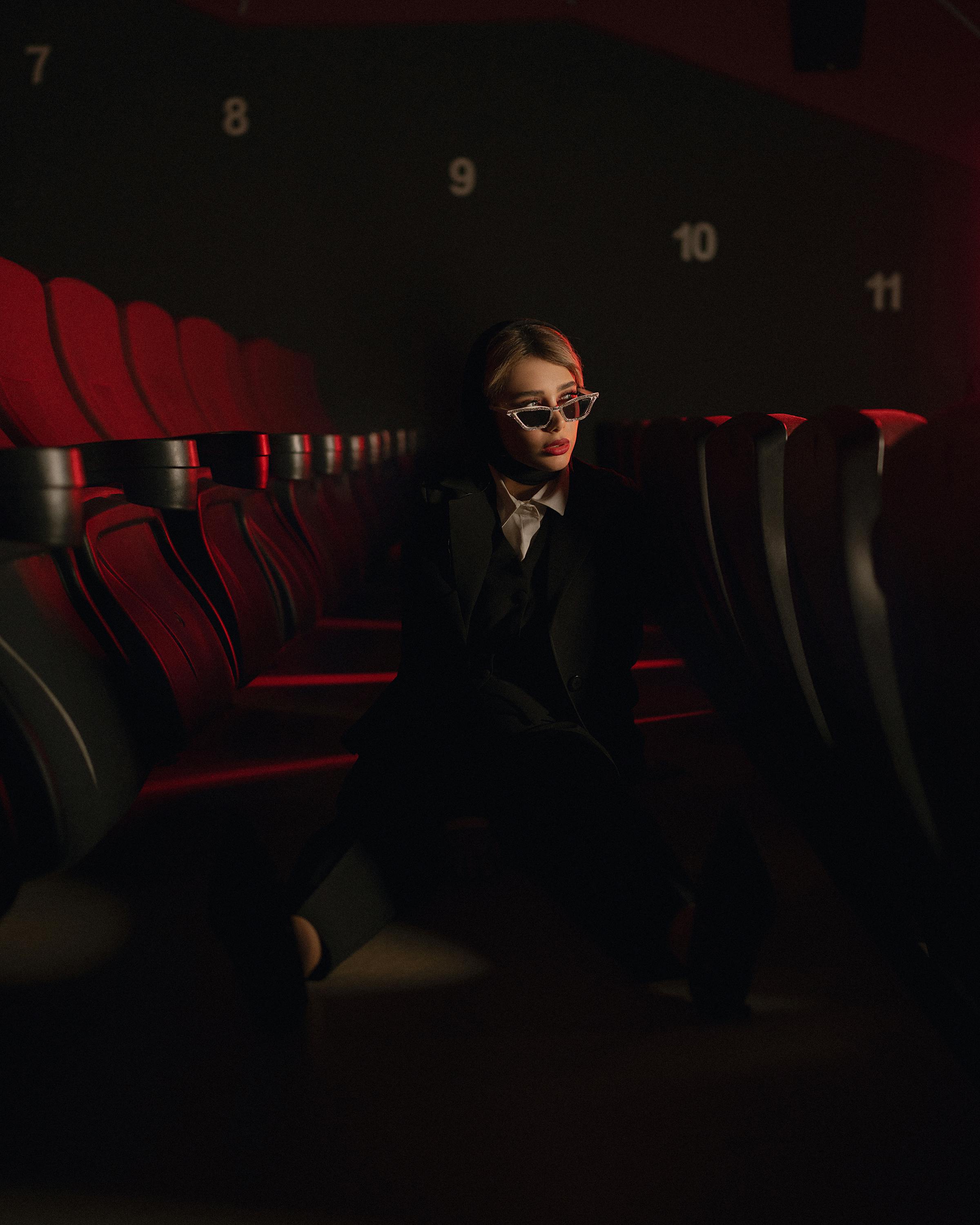 Gratis En Kvinne Som Sitter I En Mørk Kino  Arkivbilde