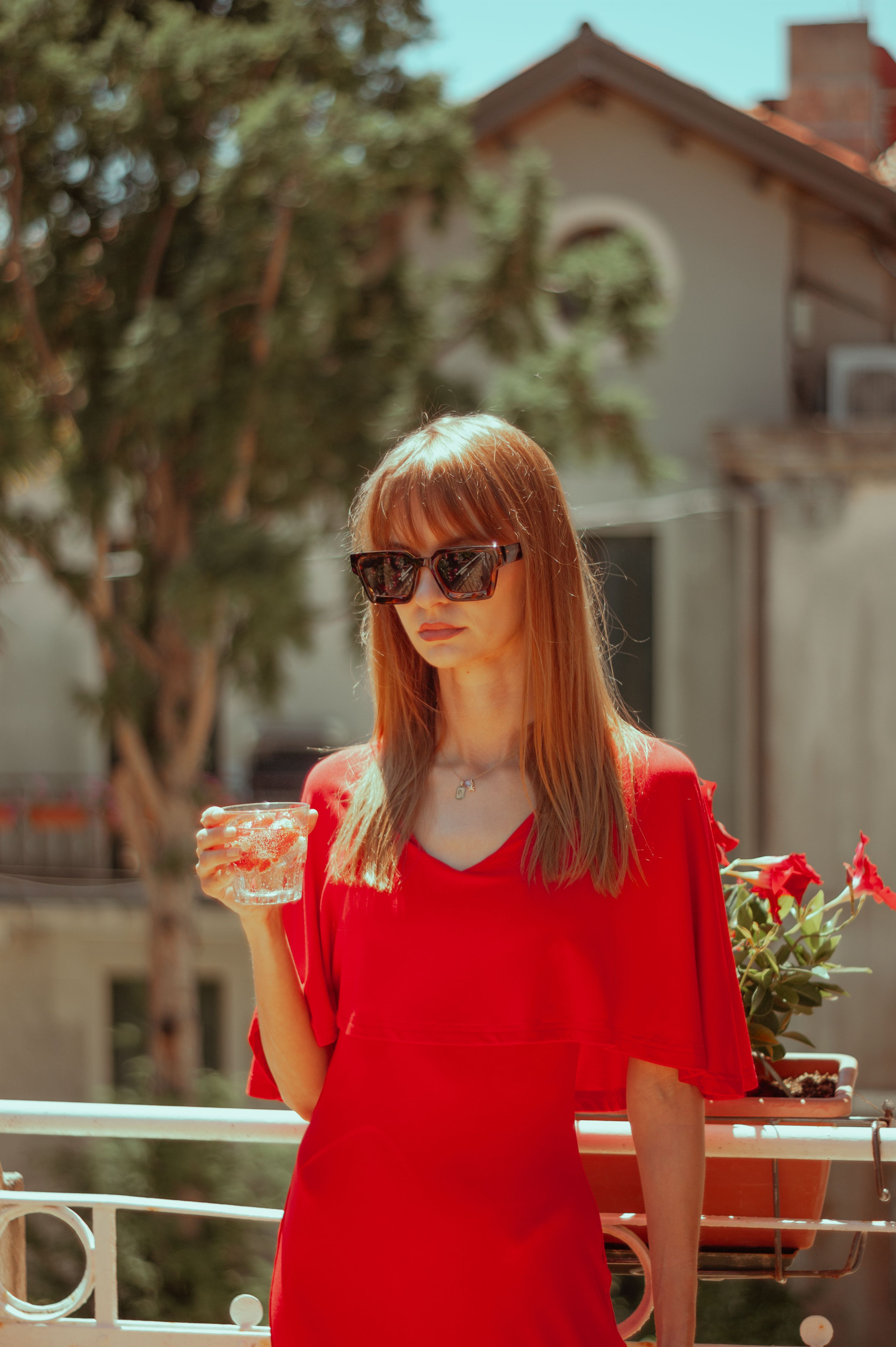 A woman in a red dress is holding a glass of wine · Free Stock Photo