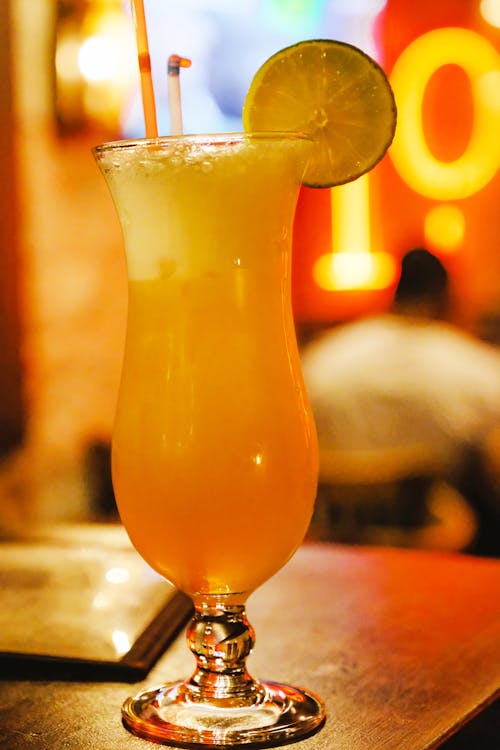 Shallow Focus Photo Of Orange Liquid On Footed Glass Cup