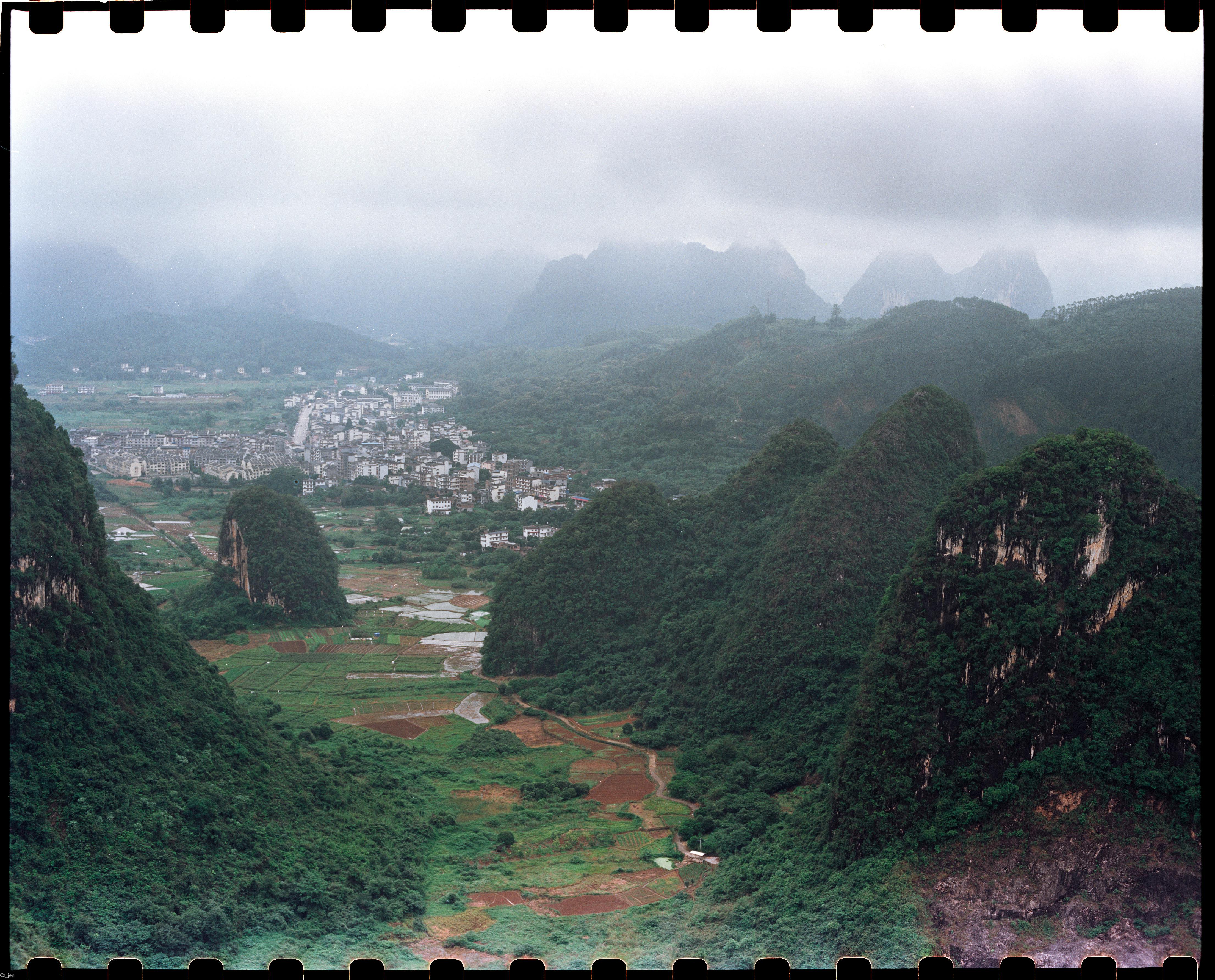 Beautiful misty mountain landscape with a village nestled in a lush green valley.