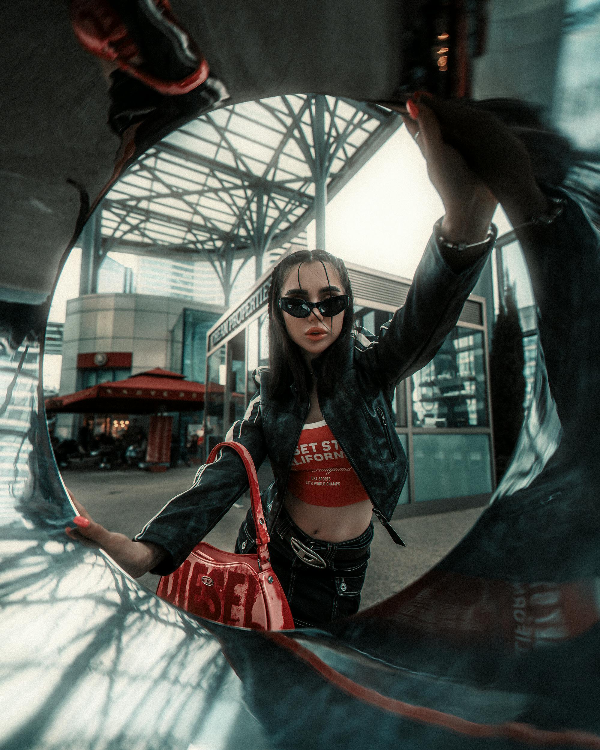 young woman in a trendy outfit posing in city