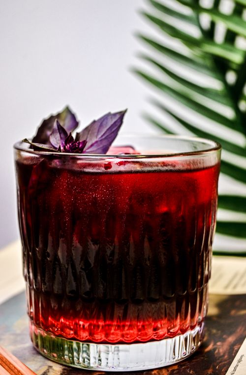 Free Close-up of a cold drink with purple basil and palm leaf background. Stock Photo