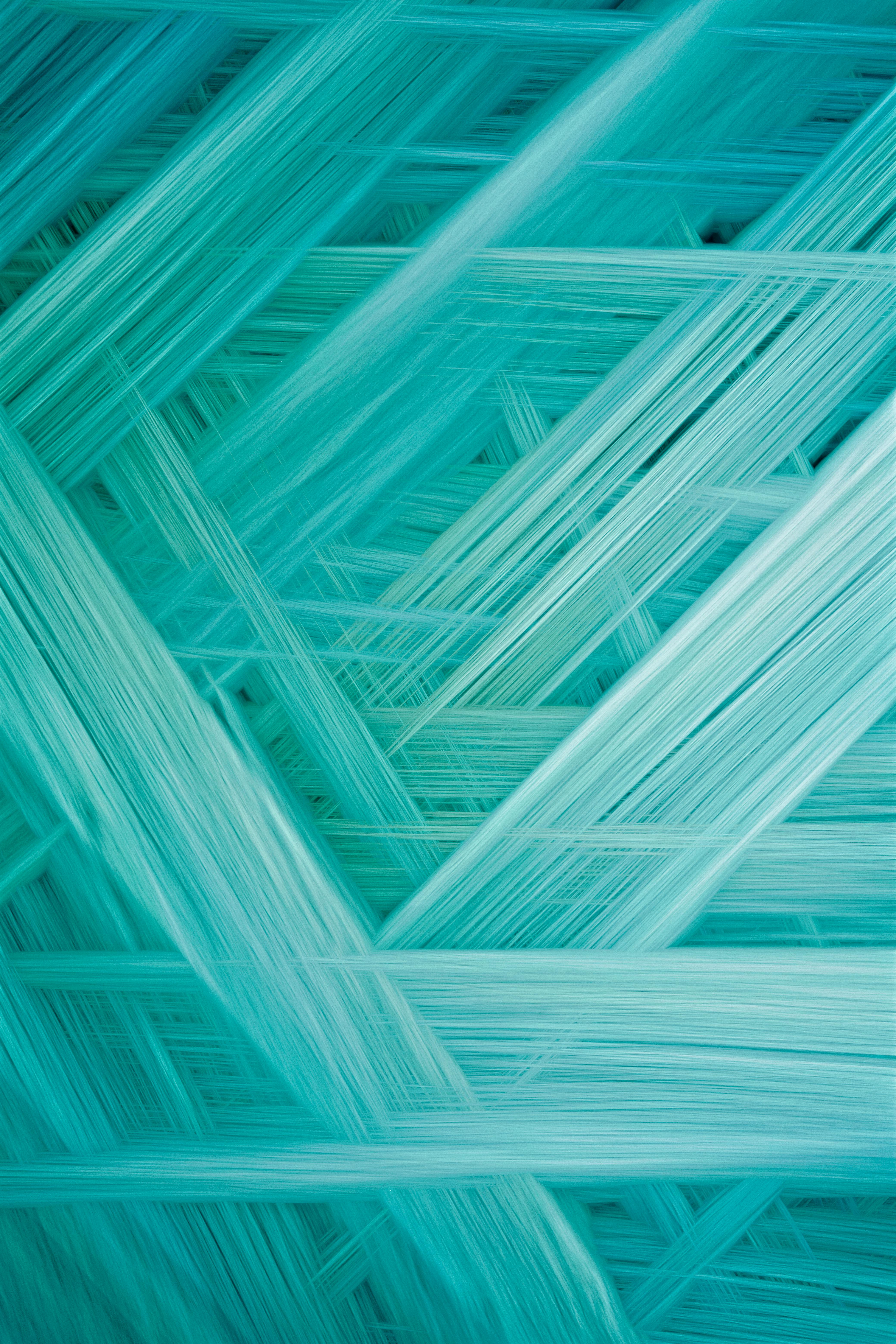 A vibrant abstract pattern of turquoise fibers, ideal as a modern background or textured wallpaper.