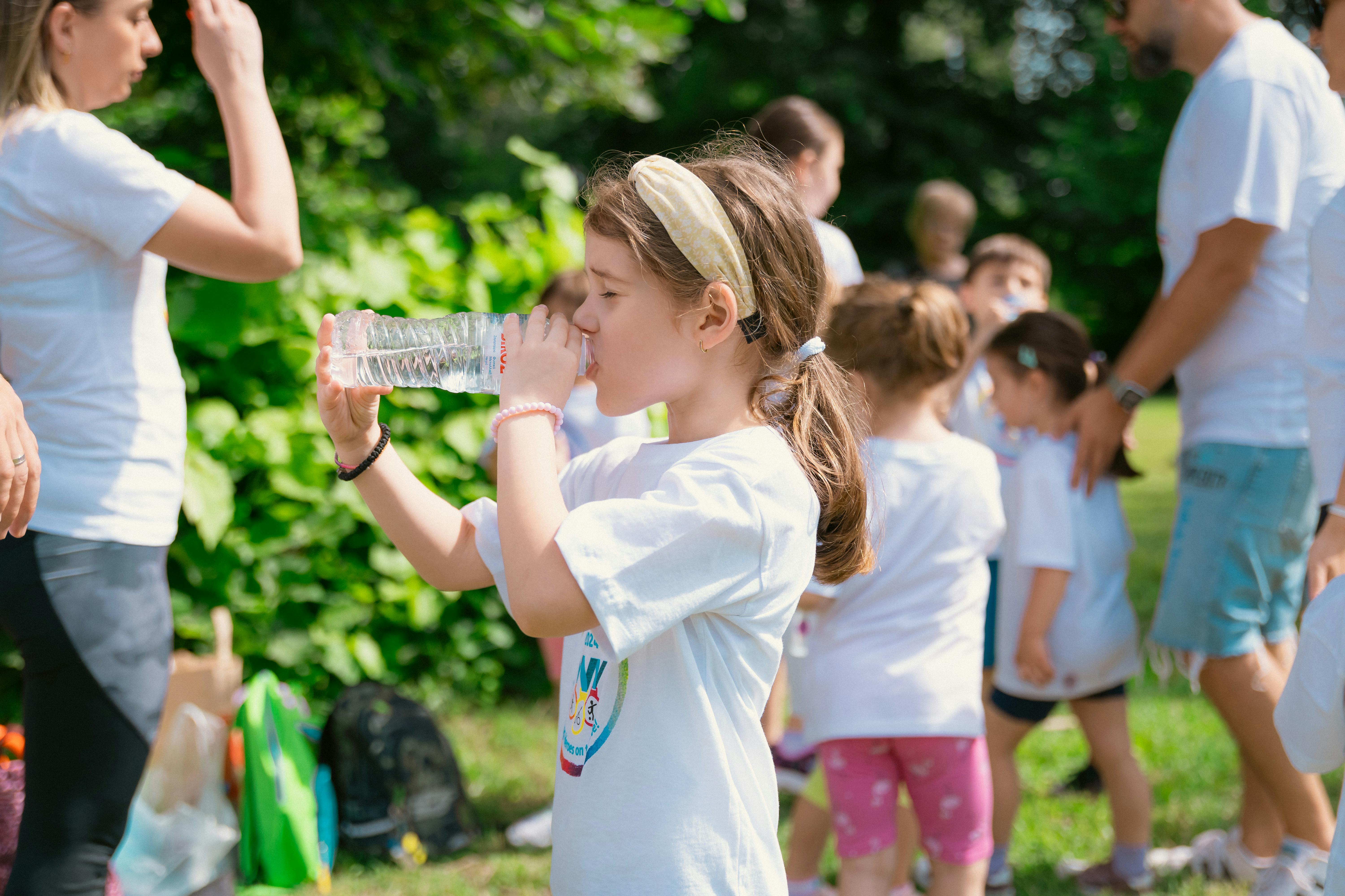 Children Hydrating While Playing In Sun
