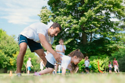 A man and a little girl doing pushups in the park