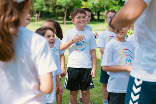 A group of children in white shirts and blue shorts