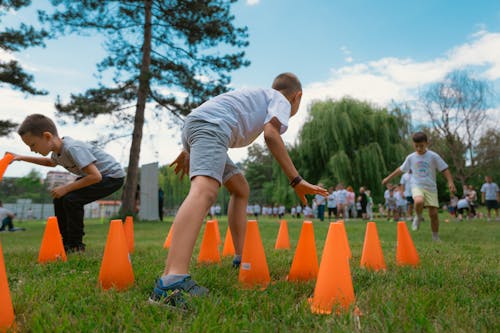Children playing with orange cones in a park