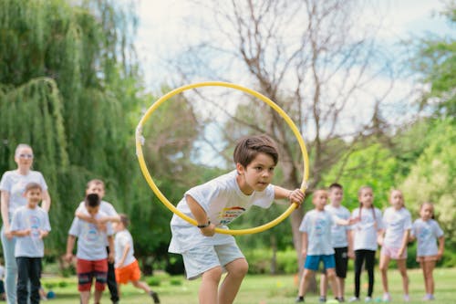 A boy is holding a hula hoop in the air