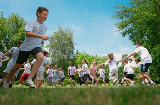 A group of children happily playing in a sunny park, enjoying outdoor activities and fun.
