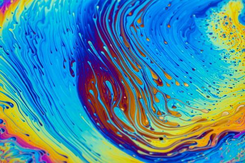 Free Dynamic abstract image featuring vivid swirls of blue, yellow, and orange paint, creating a stunning wave-like pattern. Stock Photo
