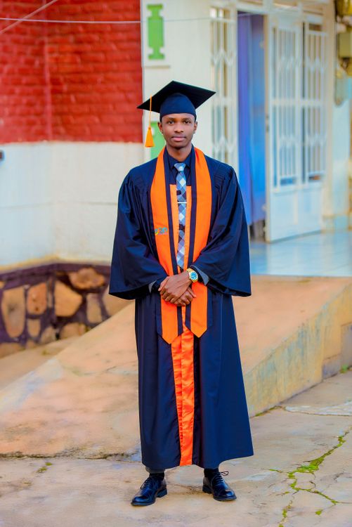 Male Graduate Wearing a Graduation Gown and a Mortarboard  Free Stock Photo