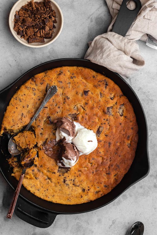 A skillet with a scoop of chocolate chip cookie