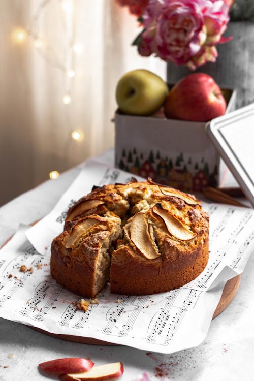 A cake with apples on top is on a table