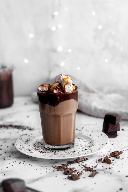 A glass of hot chocolate with marshmallows and chocolate