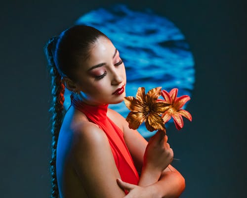 A woman in red dress holding a flower