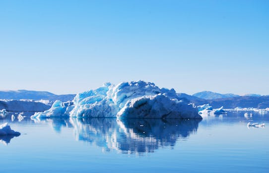 Stunning view of iceberg reflecting in calm waters of Tiniteqilaaq, Greenland.