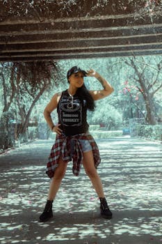 A stylish woman poses confidently in a park in Mexico City, blending urban and nature elements.