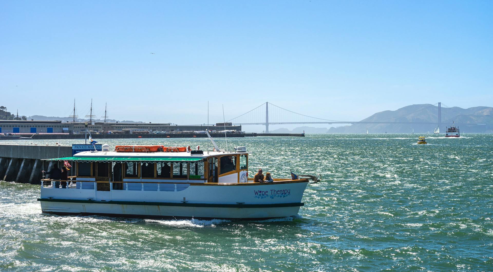 Scenic view of a ferry sailing on San Francisco Bay with the Golden Gate Bridge in the background.