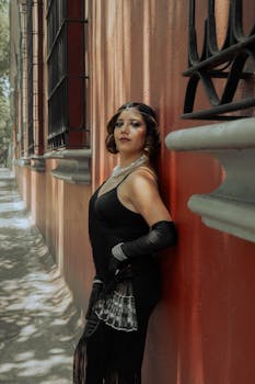 Stylish woman in black dress and pearls posing outdoors in Ciudad de México.