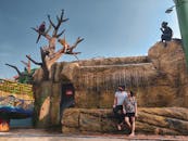 一对夫妇在风景优美的公园里欣赏着动物雕塑和人造瀑布