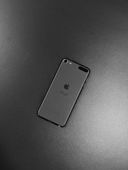 Close-up of a black iPod on a dark surface, showcasing minimalist design and modern technology.